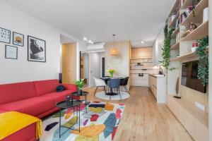 a living room with a red couch and a table at On the Danube, city center, free parking in Bratislava