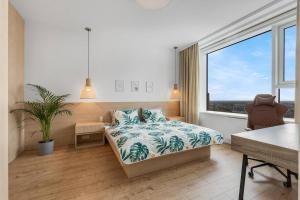 a bedroom with a bed and a large window at On the Danube, city center, free parking in Bratislava