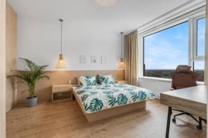 een slaapkamer met een bed en een groot raam bij On the Danube, city center, free parking in Bratislava