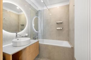 a bathroom with a sink and a tub and a mirror at On the Danube, city center, free parking in Bratislava