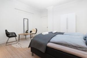 1 dormitorio con 1 cama, mesa y sillas en Come Stay in Aarhus - Close to everything 4 people en Aarhus