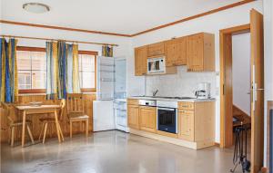 a kitchen with wooden cabinets and a table and a kitchen with a stove at Nice Home In Ebensee With Ethernet Internet in Ebensee