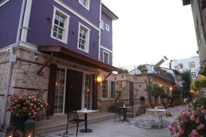 a purple building with tables and chairs in a courtyard at Top Flat with Lovely Garden near Hadrian's Gate 