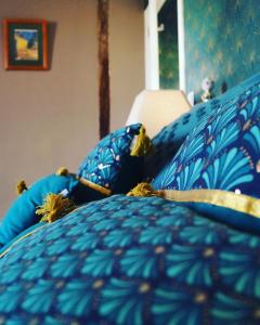 a close up of a bed with blue pillows at Maison Des Glycines in Droux