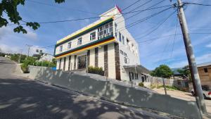 a white building on the side of a street at Dehills Hotel Luwuk in Luwuk