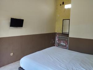 - une chambre avec un lit et une télévision murale dans l'établissement OYO Life 93265 Kos Cendana Seruni Raya, à Mataram