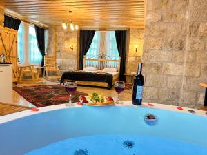 a room with a tub with two glasses of wine at Tantan Cappadocia House in Avcılar
