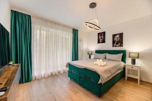 a bedroom with a green bed and green curtains at Blue Moon Apartments in Braşov