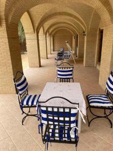 patio z niebiesko-białymi krzesłami i stołem w obiekcie SANDROSE w mieście Tauzar