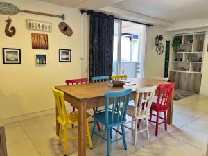 comedor con mesa de madera y sillas coloridas en Garden Novo Campeche - apartamento com jardim privativo, bem próximo à praia, en Florianópolis