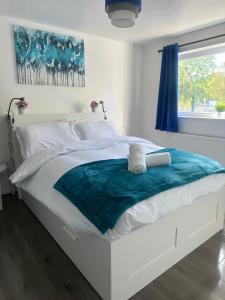 a white bed with a blue blanket on it at The Rodher house in Manchester