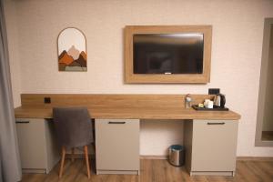 a desk with a television and a mirror on a wall at Rush Hotel Tokat in Tokat