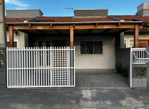 a white gate in front of a house at Casa Itajuba, Barra Velha, 20km do Beto Carrero in Barra Velha