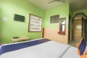 - une chambre avec un lit et un mur vert dans l'établissement SPOT ON Valley Meadow, à Srinagar