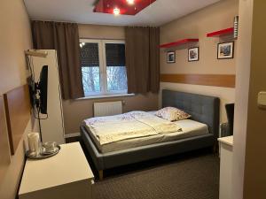 niewielka sypialnia z łóżkiem i oknem w obiekcie Zajazd Alicja w Kutnie