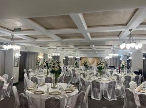 a banquet hall with white tables and chairs and flowers at Goldenburg Residence in Plovdiv +84 photos