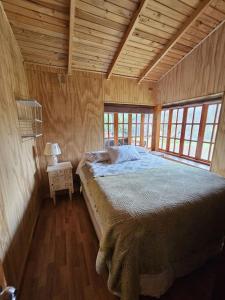 1 dormitorio con 1 cama en una casa de madera en Casa familiar yumbel con opcion a tinaja, 