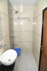 a bathroom with a shower with a sink and a toilet at Hotel Apex, Akkalkot in Akalkot