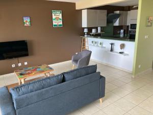ein Wohnzimmer mit Sofa und Tisch in der Unterkunft MAGNIFIQUE APPARTEMENT VUE MER, SUITE PARENTALE. in Les Trois-Îlets