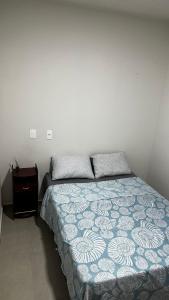 a bedroom with a bed and a night stand at Casa Itajuba, Barra Velha, 20km do Beto Carrero in Barra Velha
