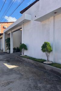 a white building with two trees in front of it at Pousada Cactus in Barreirinhas