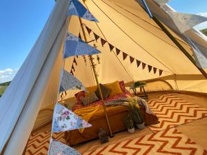 Una cama en una tienda con banderas. en Hunstanton Glamping, en Heacham