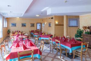 a restaurant with red and blue tables and chairs at Residence Stofol in Aprica