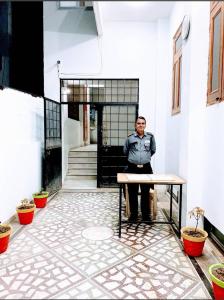 a man sitting at a table in front of a building at TUTEE HOMES RADHA in Kota