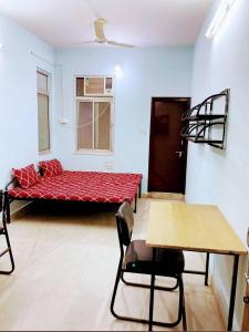 a room with a red couch in a room at TUTEE HOMES RADHA in Kota