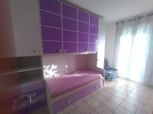 um quarto com armários roxos e uma cama roxa em Casa puntone em Puntone di Scarlino