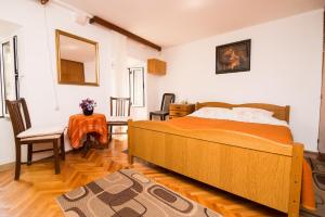 a bedroom with a bed and a table and a chair at Rooms Ane Old Town in Dubrovnik