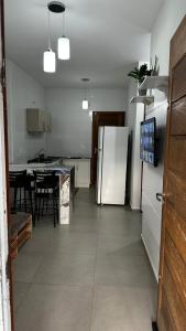 a kitchen with a refrigerator and a table with chairs at Casa Itajuba, Barra Velha, 20km do Beto Carrero in Barra Velha