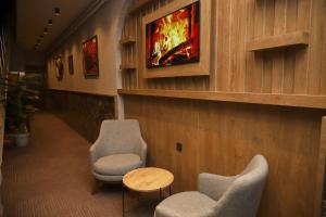 - une salle d'attente avec 2 chaises et une télévision murale dans l'établissement Rush Hotel Tokat, à Tokat