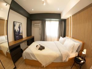 Habitación de hotel con cama y espejo en The Cabin Tagaytay City by John Morales en Tagaytay