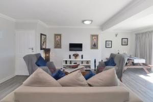 a living room with a couch and a tv at Redsky self catering Agulhas in Agulhas