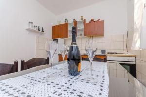 a bottle of wine sitting on a table with two wine glasses at Apartment Olga in Trogir
