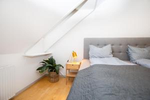 Un dormitorio con una cama y una mesa con una planta en Come Stay in An oasis of life, comfort & style en Aarhus