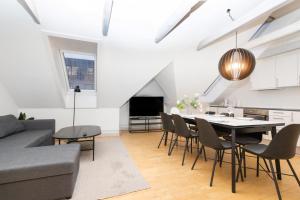 uma sala de estar com uma mesa e cadeiras e um sofá em Come Stay in An oasis of life, comfort & style em Aarhus