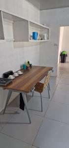 a wooden table in a kitchen with a chair at Salama Guest House in Lusaka
