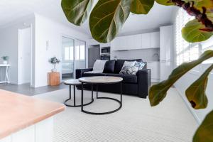 a living room with a couch and a table at Freshly Renovated Modern Waterfront 1 Bedroom unit in Gold Coast