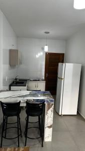 a kitchen with a counter and a refrigerator at Casa Itajuba, Barra Velha, 20km do Beto Carrero in Barra Velha