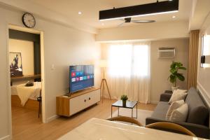 a living room with a couch and a tv at The Cabin Tagaytay City by John Morales in Tagaytay +5 photos