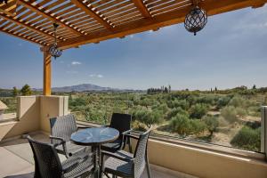 a balcony with chairs and a table and a view at Azor Luxury Villa I in Mouzákion