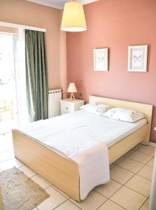 1 dormitorio con 1 cama grande y paredes de color rosa en Spacious & Bright flat with balcony en Lávrion