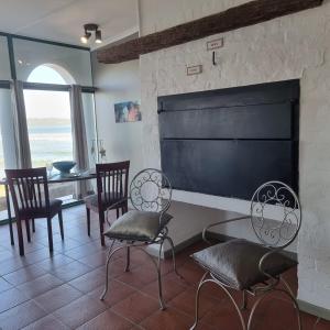 a living room with chairs and a large fireplace at Raaswater Self Catering in Langebaan