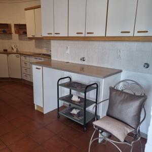 a kitchen with a counter and a chair and a table at Raaswater Self Catering in Langebaan