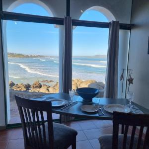 a dining table with a view of the ocean at Raaswater Self Catering in Langebaan