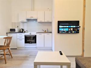 a kitchen with white cabinets and a tv on the wall at Brno apartment in Brno