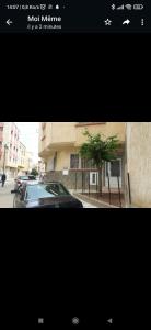 uma fotografia de um carro estacionado em frente a um edifício em Appartement meublé em Meknès