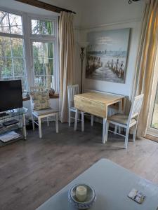 un soggiorno con tavolo e sedie in legno di The garden apartment a St Ives